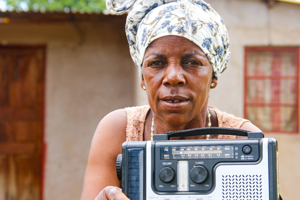 Comaco female farmer shows off solar radio
